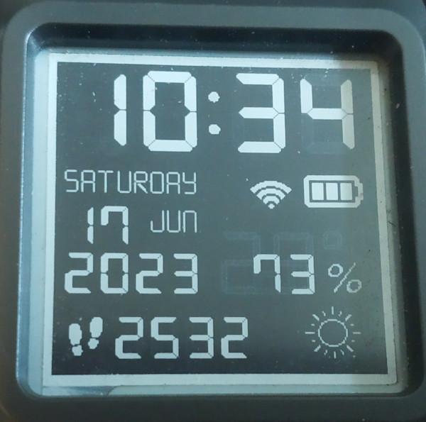 Photograph of my Watchy display. It's the 7seg watchface like the screenshot at the top of this section. However, instead of temperature, the display is showing 73% to indicate what level of our power usage today was self sufficient